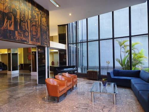 a lobby with a couch and chairs and a table at Alta Reggia Plaza Hotel in Curitiba
