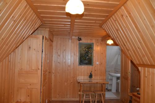 Habitación con paredes de madera, mesa de madera y sillas. en Pokoje Gościnne U Gordona en Poronin