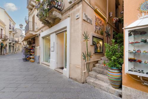 a street in an old town with shops and plants at ELEGANT APARTMENT IN TAORMINA in Taormina