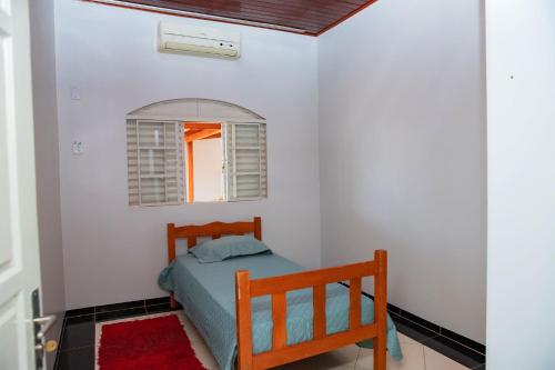 a small bedroom with a bed and a window at Casa com Wi-Fi e otima localizacao em Juina MT in Juína