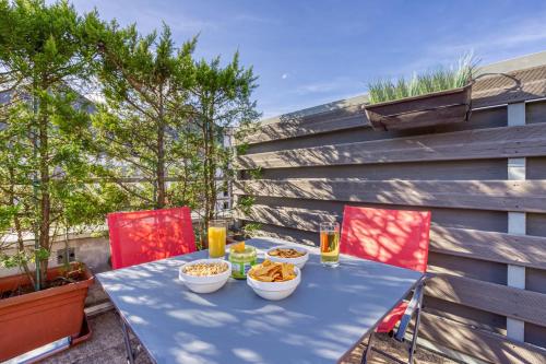 une table bleue avec des bols de nourriture sur une terrasse dans l'établissement La terrasse Disney/Gare/Centre à 3min parking free, à Montévrain