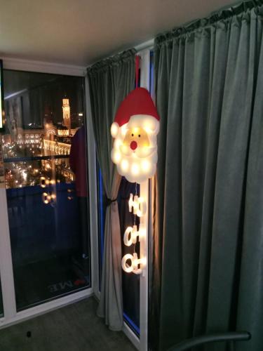 a santa claus light in a room with a window at APARTMAN POZORISTE Penthaus in Banja Luka