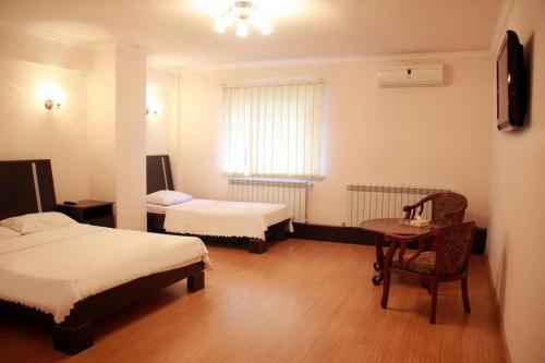 Habitación con 2 camas, mesa y ventana en Nur Hotel en Ereván