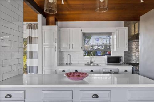 a kitchen with white cabinets and a bowl on a counter at Hollywood Hideaway in Los Angeles