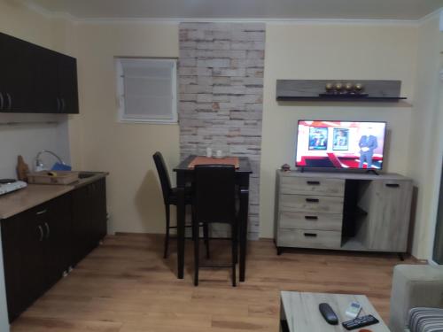 een keuken met een tafel en stoelen en een televisie bij Zone Knezevac in Belgrado