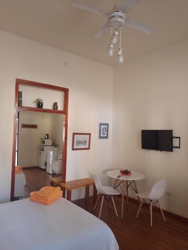 1 dormitorio con cama, mesa y TV en Monoambiente en Puerto Nuevo en Concepción del Uruguay