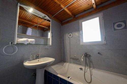 uma casa de banho com um lavatório e uma banheira e um lavatório em FarmBill em Markopoulon