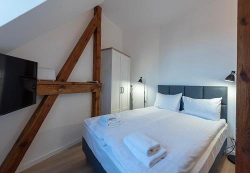 a bedroom with a large white bed with a flat screen tv at PROVENIR HOME KWIATOWA 5 in Poznań