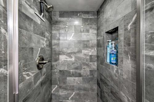 uma casa de banho com um chuveiro com azulejos cinzentos em Airy Destin Condo with Pool - Walk to Private Beach! em Destin