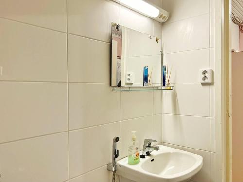 ein weißes Badezimmer mit einem Waschbecken und einem Spiegel in der Unterkunft Finnish house near the forest in Lappeenranta