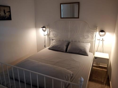 Un dormitorio con una cama blanca con dos luces. en Sunset and sea view, wifi and more en Ashqelon