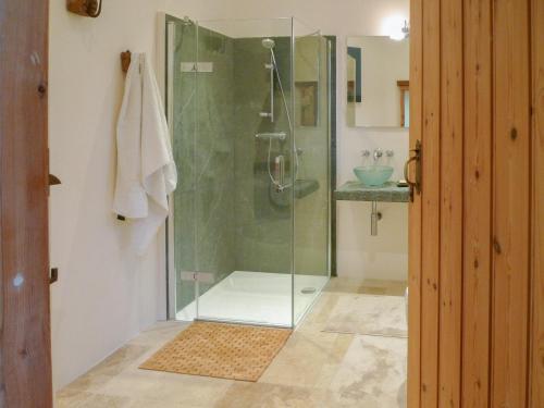 a glass shower in a bathroom with a sink at The Coach House in Syston