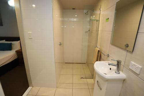 a bathroom with a shower and a toilet and a sink at Kallangur Motel in Kallangur