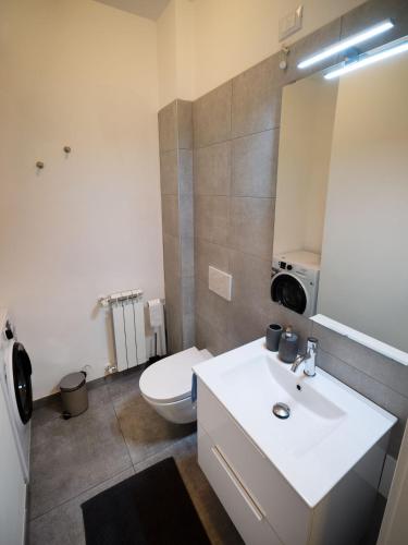 a bathroom with a white sink and a toilet at Casa Felicità in Udine