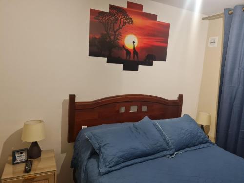 a bedroom with a bed and a picture on the wall at Hermoso departamento en condominio privado, cercano a playas y centros comerciales in El Tabo