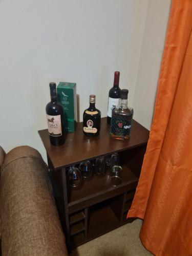a table with bottles of alcohol on it next to a couch at Hermoso departamento en condominio privado, cercano a playas y centros comerciales in El Tabo