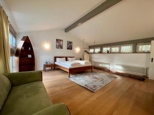 a living room with a bed and a couch at Ferienwohnung Müllheim - mit Garten und Wintergarten in Müllheim