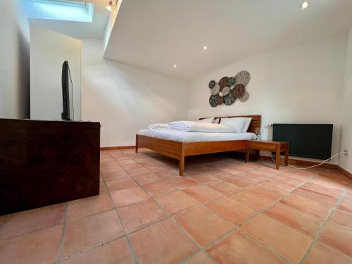 a bedroom with a bed and a tiled floor at Ferienwohnung Müllheim - mit Garten und Wintergarten in Müllheim