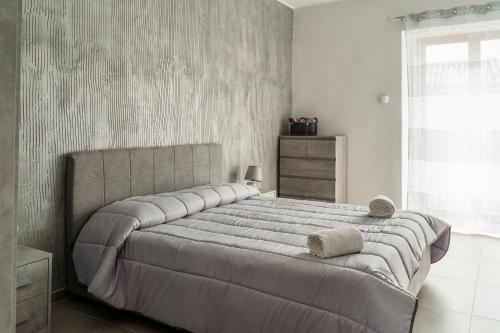 - une chambre avec un grand lit et une fenêtre dans l'établissement Delia case vacanza, à Fiumefreddo di Sicilia