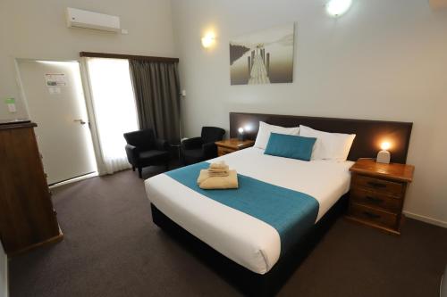 a hotel room with a bed with a towel on it at Kallangur Motel in Kallangur
