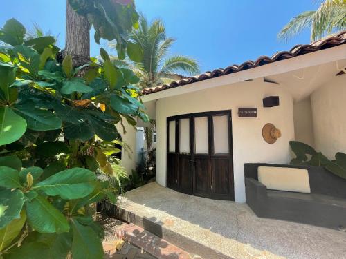 a door to a house with a bench in front at Quinta Feliz Troncones in Troncones