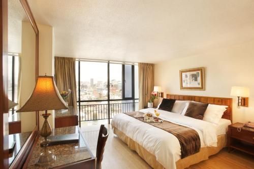 a bedroom with a large bed and a large window at Hotel Rio Amazonas in Quito