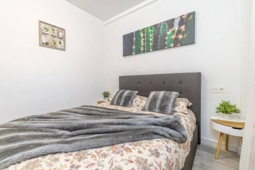 a white bedroom with a bed and a table at Punta Prima Palm Beach Apartment in Punta Prima