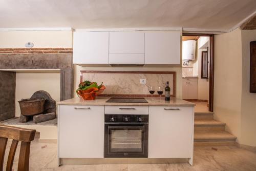 a kitchen with white cabinets and an oven at IBibiena - SUITE CECCO E MEA in Bibbiena