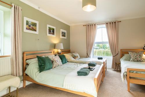 a bedroom with two beds and a couch at The Cedars in Builth Wells