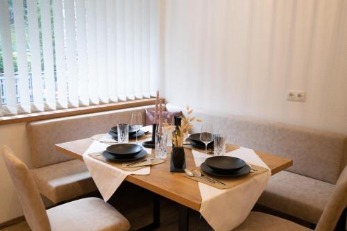 a wooden table with plates and utensils on it at W-Spirit Apartments in Jerzens