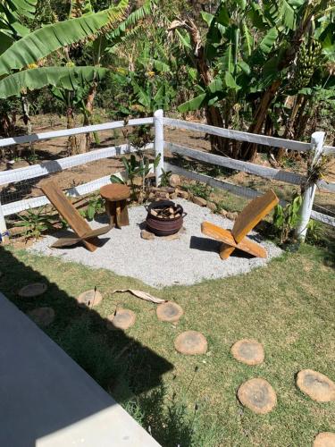 a garden with a wooden bench and a fire pit at Casinhas em Terras Frias in Santa Maria Madalena