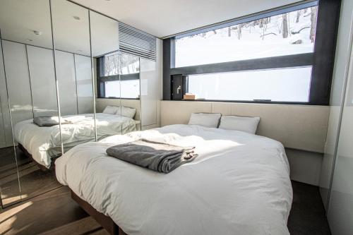 a bedroom with two beds and a large window at Sapporo - House - Vacation STAY 13790 in Sapporo