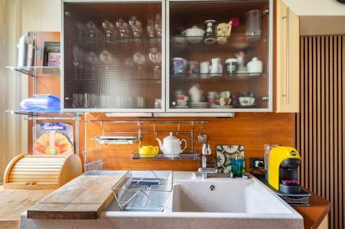 una cocina con fregadero y un estante con platos en Duomo Apartment CIR 017029-CNI-00186, en Brescia
