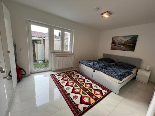 ein Schlafzimmer mit einem Bett und einem Teppich auf dem Boden in der Unterkunft Wunderschöne Unterkunft mit Terrasse - 24h7t Checkin in Karlsruhe