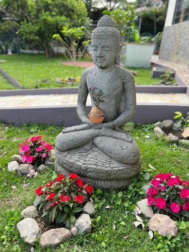 a statue of aitating woman with a plant in her lap at Jardín del Edén in Bajo Boquete