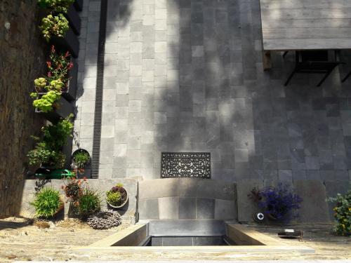 a stone bench in front of a building with plants at B&B En face du Marronnier in Cornimont