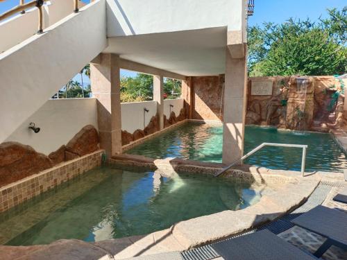 a swimming pool in a house with a water slide at Hotel Spa el Gran Coral By Rotamundos in Jocotepec