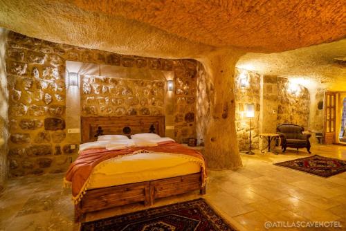 a bedroom with a bed in a stone wall at Atilla's Cave Hotel in Nevsehir