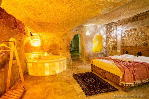 a bedroom with a bed and a bath tub at Atilla's Cave Hotel in Nevşehir