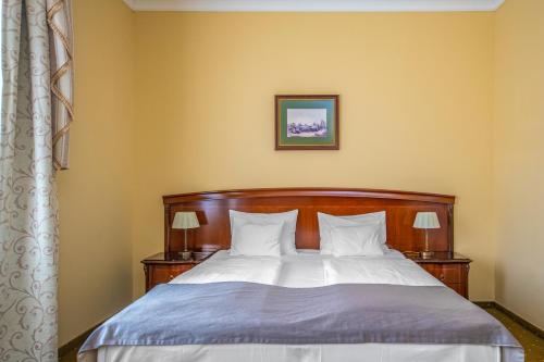 a bedroom with a large bed with two night stands at La Contessa Castle Hotel in Szilvásvárad