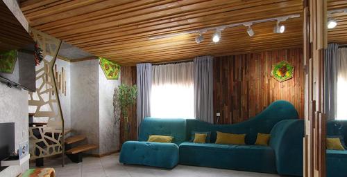 a living room with a blue couch and a window at Four Seasons In Carpathians in Migovo