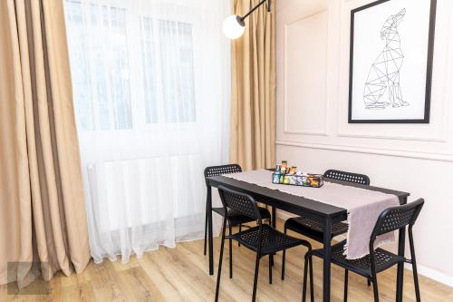 une salle à manger avec une table et des chaises noires dans l'établissement Urban Nest, à Zalău