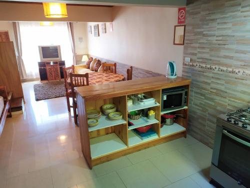 a kitchen and living room with a counter with dishes at Departamentos Turísticos J&M en Dichato in Dichato