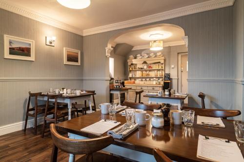 a restaurant with wooden tables and chairs and a counter at The Cedars in Builth Wells