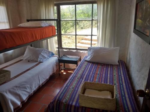 2 Betten in einem Zimmer mit Fenster in der Unterkunft Tuminica Lodge - Chalet de montaña en Suesca in Suesca