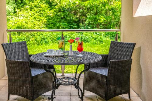 a table with chairs and drinks on a patio at La Contessa Castle Hotel in Szilvásvárad