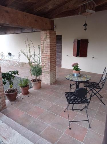 a patio with a table and chairs and plants at b&b CASCINA SORTINA Country House in Ozzano Monferrato