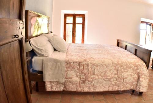 a bedroom with a large bed with a wooden frame at b&b CASCINA SORTINA Country House in Ozzano Monferrato