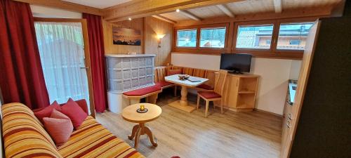 ein kleines Wohnzimmer mit einem Sofa und einem Tisch in der Unterkunft Appartements Alpenland - Ferienwohnungen in Auffach