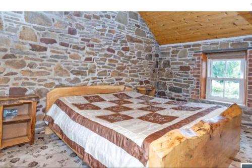 - une chambre avec un lit dans un mur en pierre dans l'établissement 2 Bed Sandstone Residence, à Newport